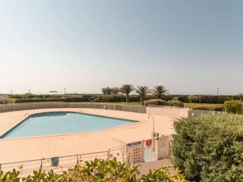 une grande piscine entourée d'une clôture. dans l'établissement Les Rivages de Rochelongues, T3, piscine, clim, parking, au Cap d'Agde