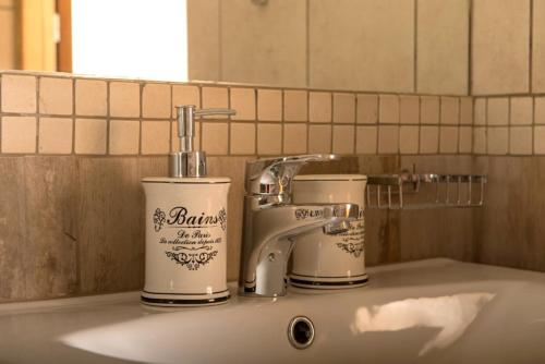 um lavatório de casa de banho com duas chávenas e uma torneira em eHotel Esztergom em Esztergom