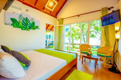 a bedroom with a bed and a window and a television at Kurumba Luxury Cabin in Ahangama