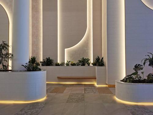 a lobby with white columns and plants and lights at Casino Residences 1 & 2 Bedroom Apartments in Gold Coast