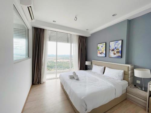 een slaapkamer met een groot bed en een groot raam bij ENCORP MARINA Residences by GW STAY in Johor Bahru
