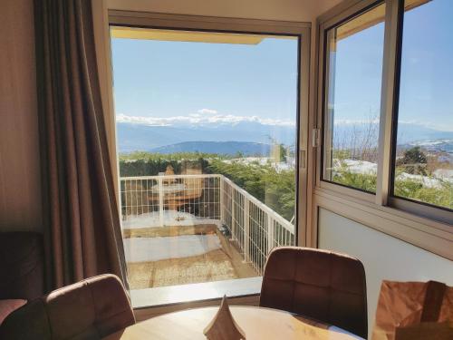 Cette chambre dispose d'une grande fenêtre donnant sur un balcon. dans l'établissement Casa Del Cargol terrasse plein sud avec vue et garage, à Font-Romeu-Odeillo-Via