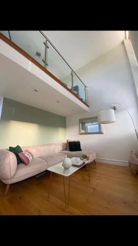 a living room with a pink couch and a table at Lovely 1-Bedroom loft apartment in Cardiff