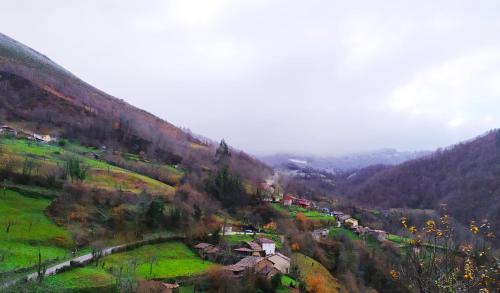 a view of a mountain with a town on a hill at La Faya - La Vallicuerra Casas Rurales in Mieres