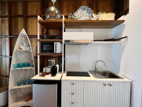 eine kleine Küche mit einer Spüle und einer Mikrowelle in der Unterkunft Sealord Naithon Beachfront Villa in Nai Thon Beach