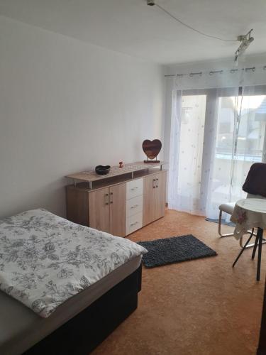 a bedroom with a bed and a desk and a window at 5 Zimmer Appartement in ruhiger Lage nähe Heilbronn in Oedheim