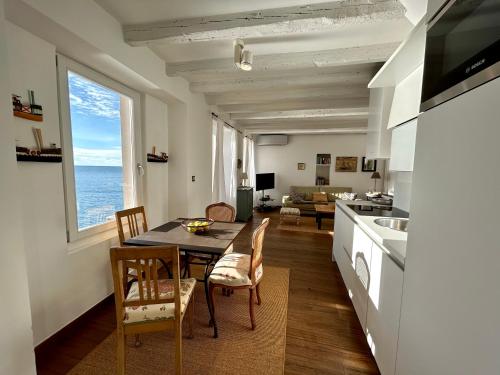eine Küche und ein Wohnzimmer mit einem Tisch und Stühlen in der Unterkunft Apartment Mediterraneo in Rovinj