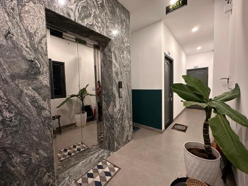 La salle de bains est pourvue d'une plante en pot et d'un mur. dans l'établissement MID NIGHT, à Cần Thơ