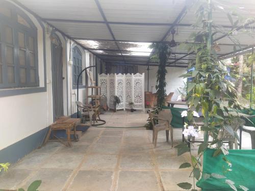 a room with a porch with chairs and a plant at Casamore in Vagator
