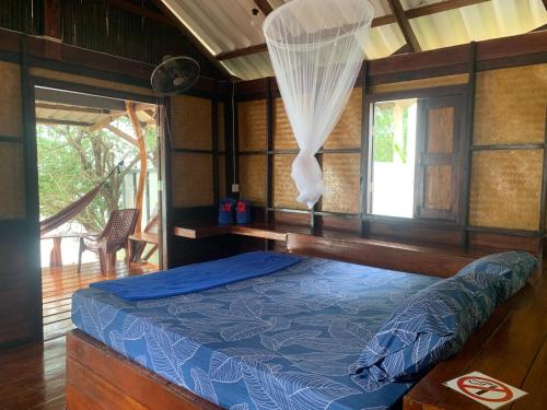 een slaapkamer met een bed in een kamer met een raam bij Pimmada Hut in Haad Pleayleam