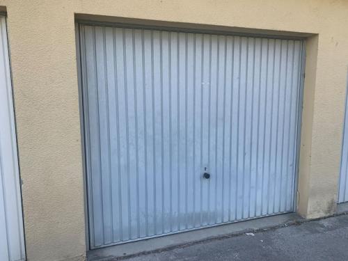 uma grande porta de garagem de metal do lado de um edifício em Hirondelle : Appartement privé avec garage em Annecy