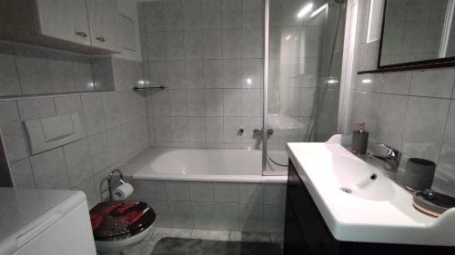 a bathroom with a tub and a sink and a toilet at Ferienwohnung Cottbuser City in Cottbus