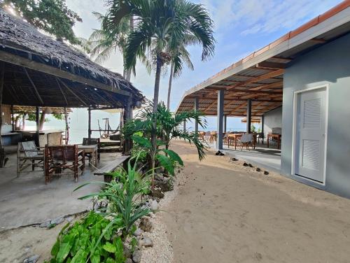 a resort with tables and chairs on the beach at Scandinavian Beach Resort in Ko Lanta