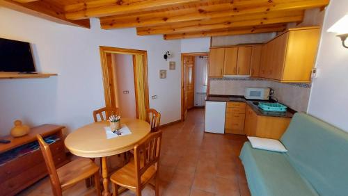 a kitchen and dining room with a table and a couch at Camping Solau in Espot
