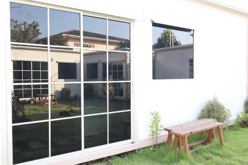 a large window on the side of a house with a bench at Homey Hut Ayutthaya in Phra Nakhon Si Ayutthaya