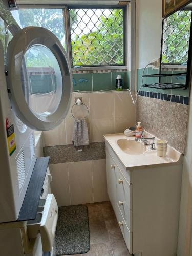a bathroom with a sink and a mirror at XYL Holiday Inn in Caloundra
