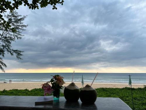a table with two melons and a view of the beach at Sealord Naithon Beachfront Villa in Nai Thon Beach