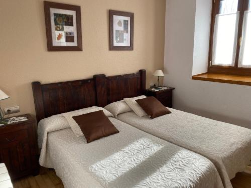 a bedroom with two beds and two pictures on the wall at TXARRENEA in Elizondo