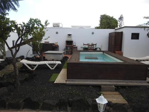 a backyard with a swimming pool and a house at Habitaciones Doña Cris in Puerto del Carmen