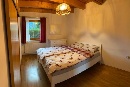 a bedroom with a bed and a window and a chandelier at Ferienhaus Gerlitzen in Köttwein