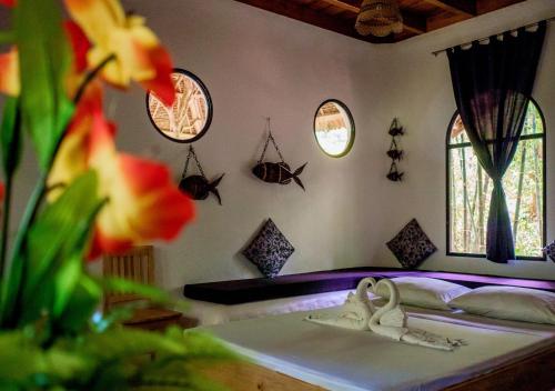 a bedroom with a bed and two windows at Kim's Garden in Anda