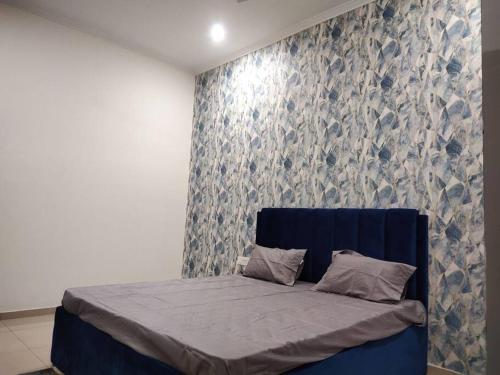 a bed in a bedroom with a blue and white wall at Sukoon Villa Jaipur 3 BHK fully furnished house in Jaipur