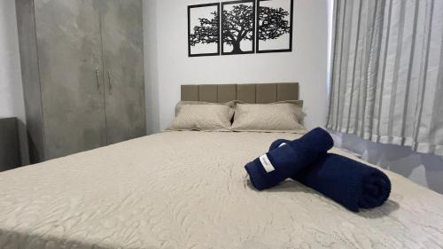 Una cama con una almohada azul encima. en Apartamento Locação Temporada em Foz do Iguaçu, en Foz do Iguaçu