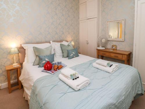 een slaapkamer met een bed met handdoeken en fruit erop bij Winkle Cottage, Aldeburgh in Aldeburgh