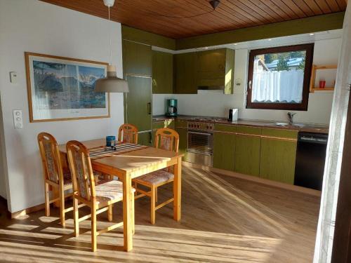 una cucina con tavolo e sedie in legno di Ferien in der Region Lenzerheide a Lenz