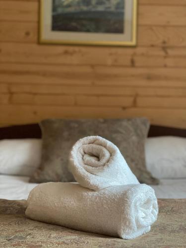 a roll of white towels sitting on a bed at Pokoje Gościnne Przy Drodze in Białka Tatrzańska