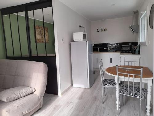 salon z kanapą i stołem oraz kuchnia w obiekcie Les pins w mieście Longeville-sur-Mer