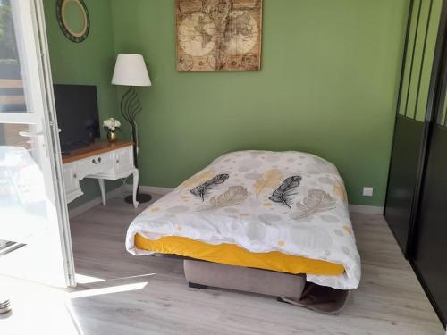 um quarto com uma cama com um cobertor e uma secretária em Les pins em Longeville-sur-Mer