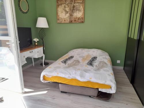 sypialnia z łóżkiem z kocem i biurkiem w obiekcie Les pins w mieście Longeville-sur-Mer