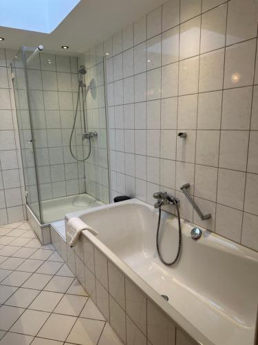 uma casa de banho branca com uma banheira e um chuveiro em Großzügige Wohnung am Stadtrand em Wurtzburgo