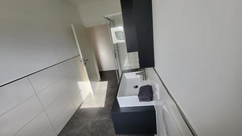 a white bathroom with a sink and a mirror at Ferienwohnung-Irxleben in Irxleben