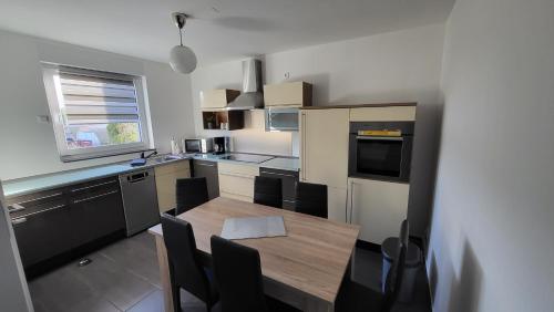 une cuisine avec une table en bois et une salle à manger dans l'établissement Ferienwohnung-Irxleben, à Irxleben