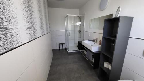 a white bathroom with a sink and a mirror at Ferienwohnung-Irxleben in Irxleben