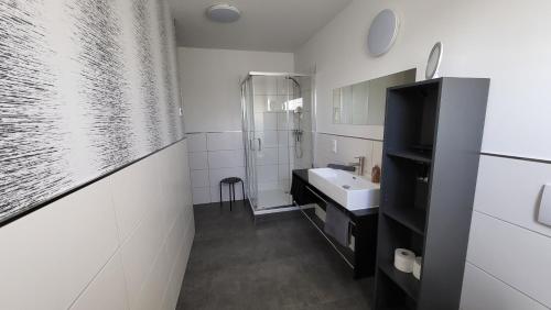 a white bathroom with a sink and a shower at Ferienwohnung-Irxleben in Irxleben