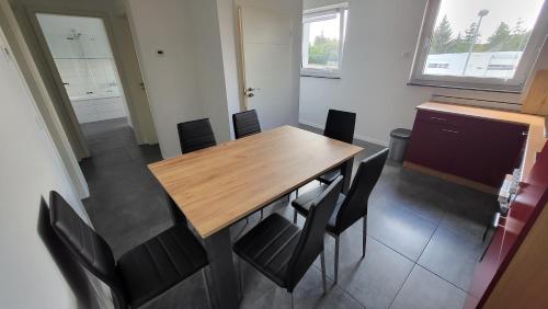 a dining room with a wooden table and black chairs at Ferienwohnung-Irxleben in Irxleben