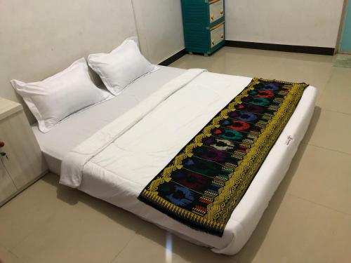 a white bed with a blanket on it in a room at Azka Homestay in Kuta Lombok