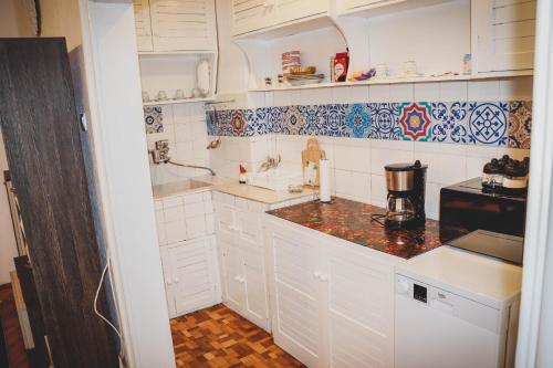 eine Küche mit weißen Schränken und blauen und weißen Fliesen in der Unterkunft 3 Rooms, Loft Apartment, Located RIGHT in CENTER!!! in Razgrad