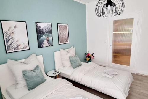 1 dormitorio con 2 camas y pared azul en Your Cozy Appartment in Wuppertal: Wupper-Home 2, en Wuppertal