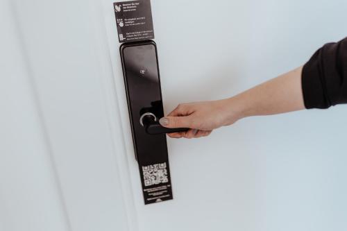 a hand is holding a door handle at City Rooms Amstetten in Amstetten
