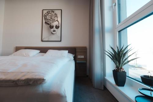 a bedroom with a bed and a large window at City Rooms Amstetten in Amstetten
