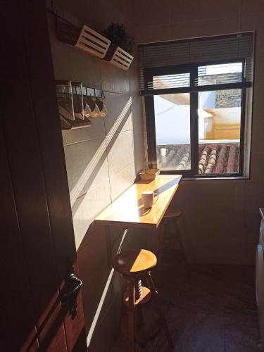 una piccola cucina con uno sgabello e una finestra di Avenida Reyes Católicos a Chiclana de la Frontera