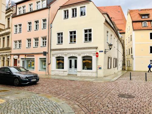a black car parked on a street with buildings at Elbsandstein-Suite direkt im Stadtzentrum in Pirna