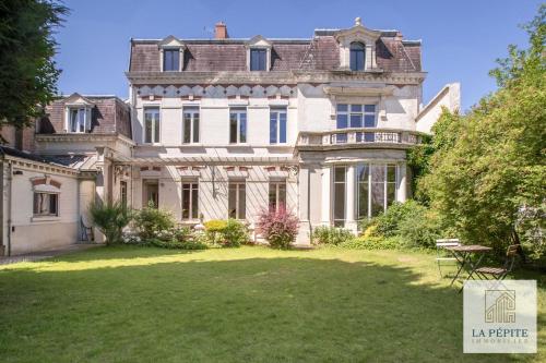 une grande maison avec une grande cour en face dans l'établissement Hôtel particulier - Le 119, à Valenciennes