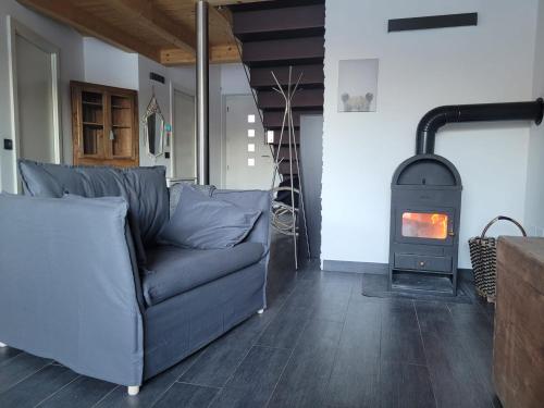 a living room with a couch and a wood stove at Relax in Pineta in Caldonazzo