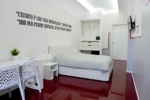 una piccola camera con letto bianco e scrivania di Il Castelluccio ad Arezzo