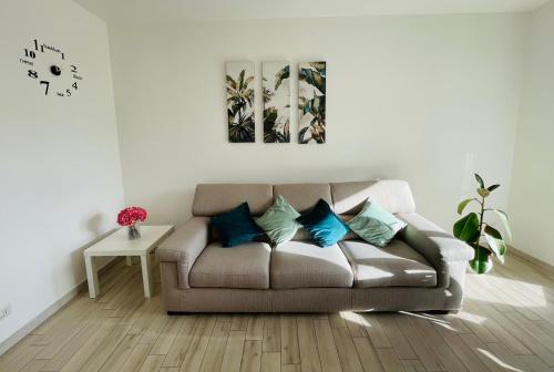 a living room with a brown couch with blue pillows at Emme Apartment IUN (Q8410) in Cagliari